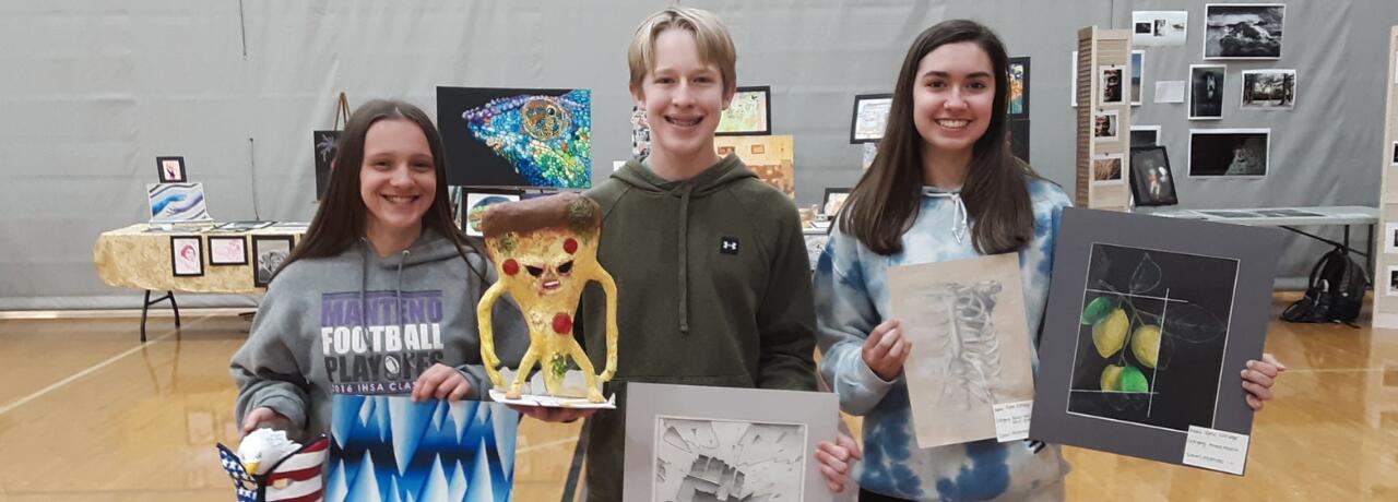 Students holding artwork